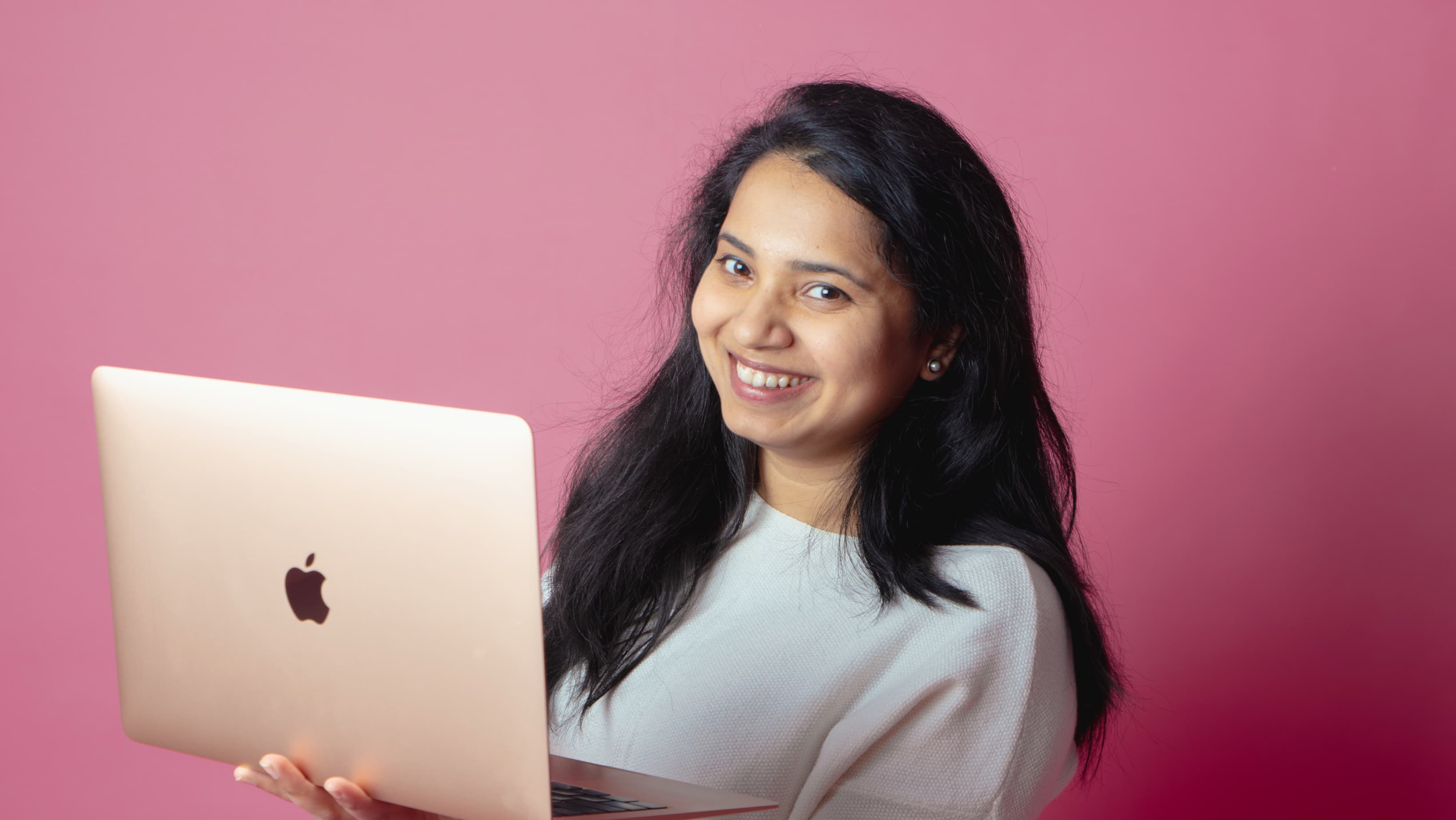 Frau, die einen Laptop hÀlt und lÀchelt