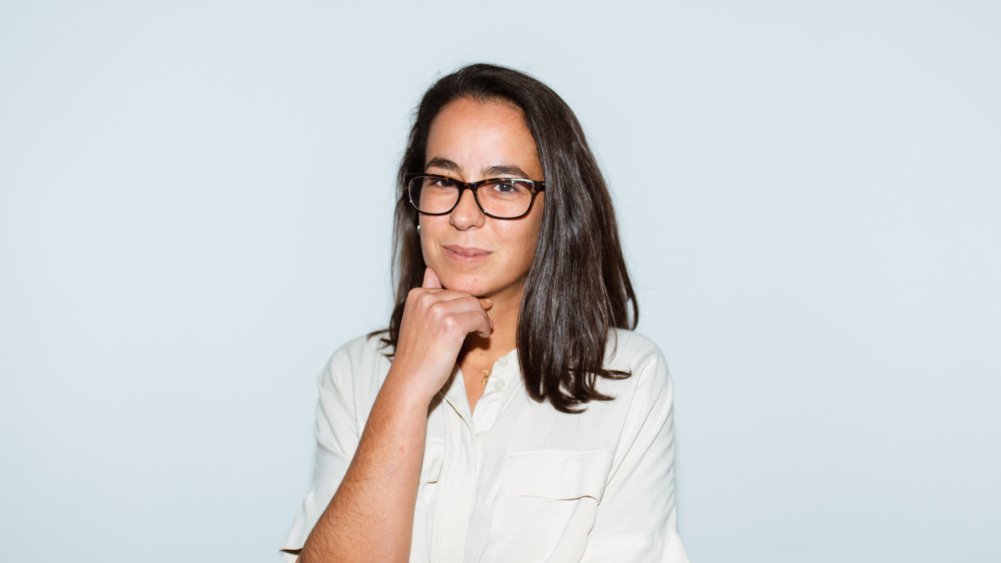 Frau mit Brille und weiĂem Hemd schaut selbstbewusst