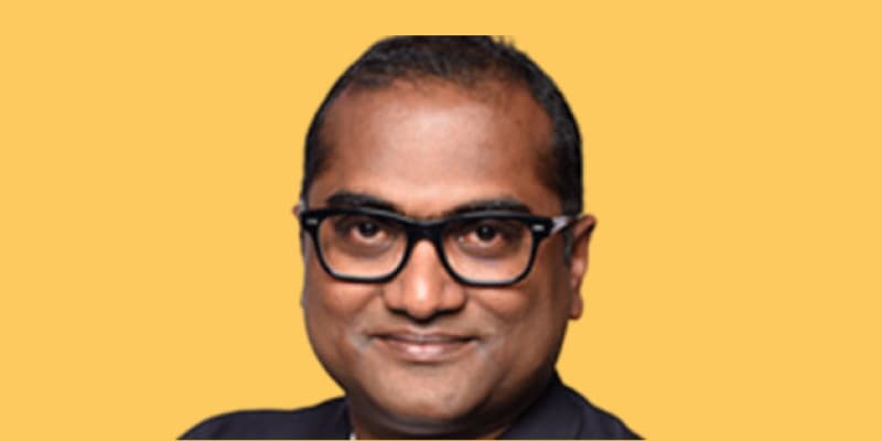 Portrait of a man wearing glasses against an orange background