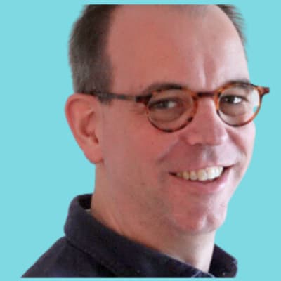 Portrait of a smiling man wearing glasses against a blue background