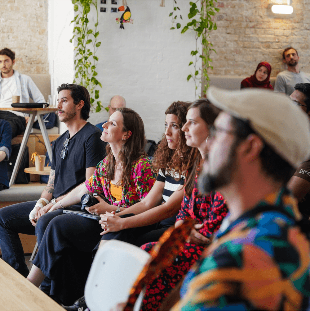 People listening attentively at an event in a cozy room.