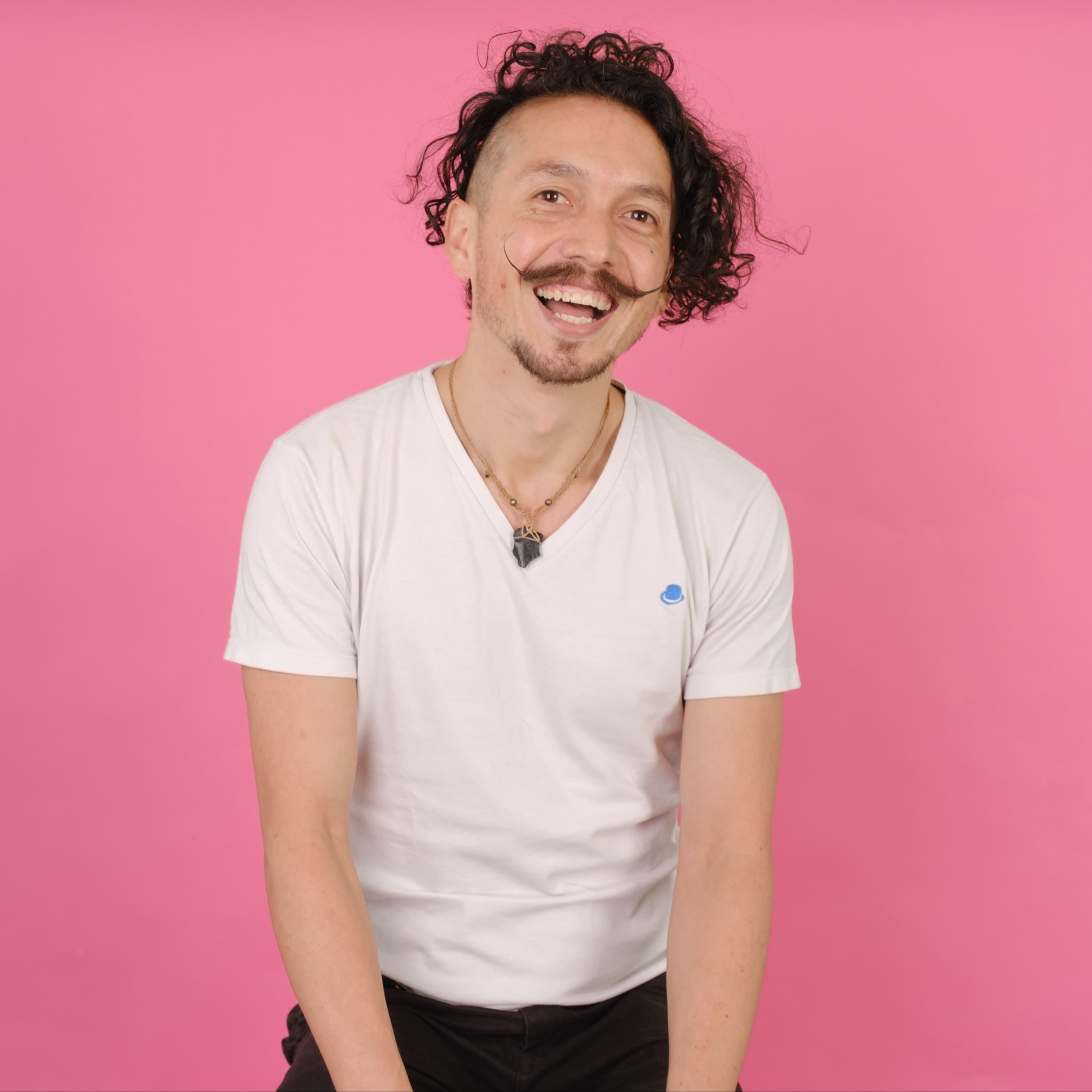 Smiling man with mustache against pink background