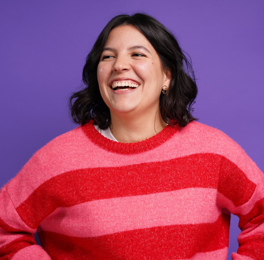Woman laughing against purple background