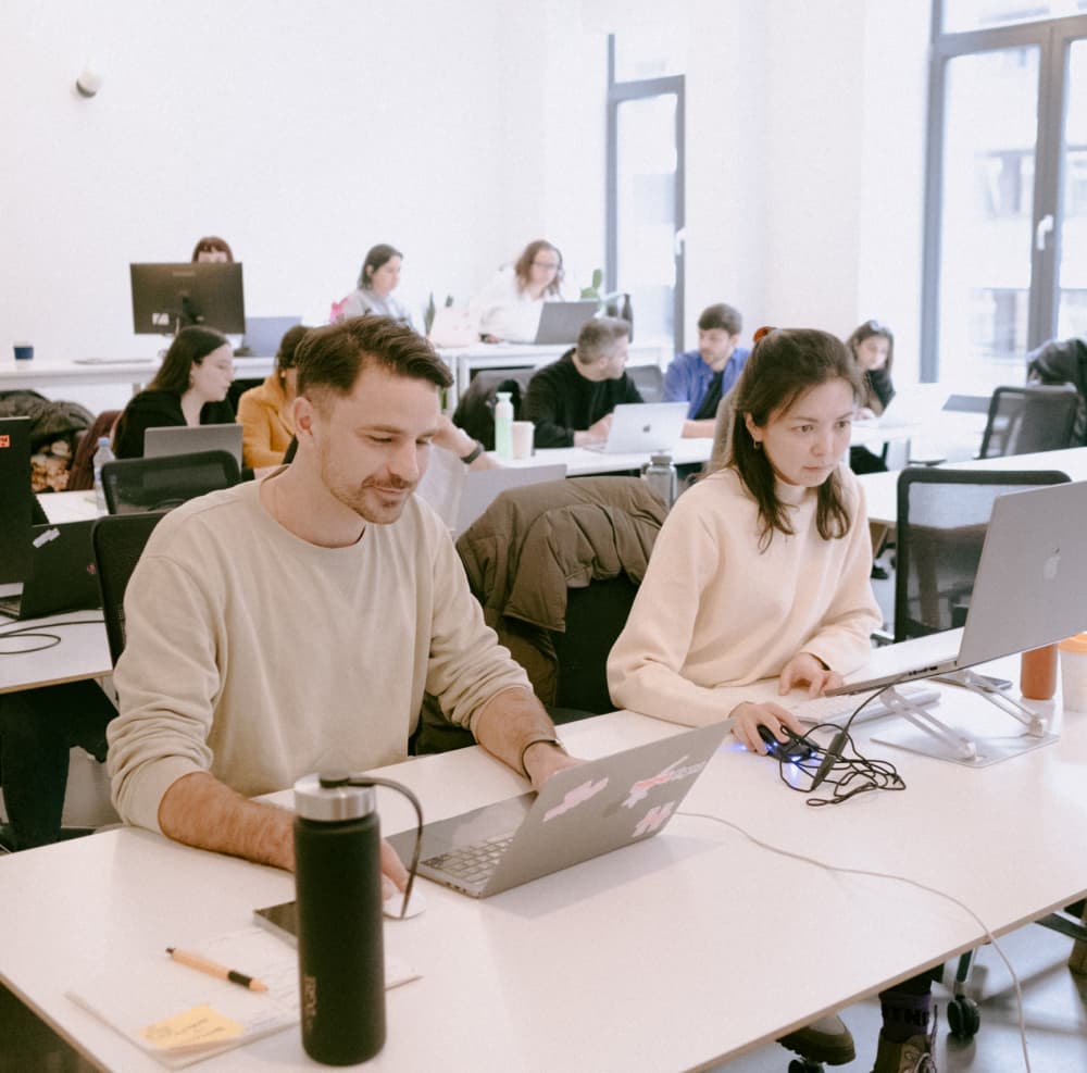 People working on laptops in a modern office.