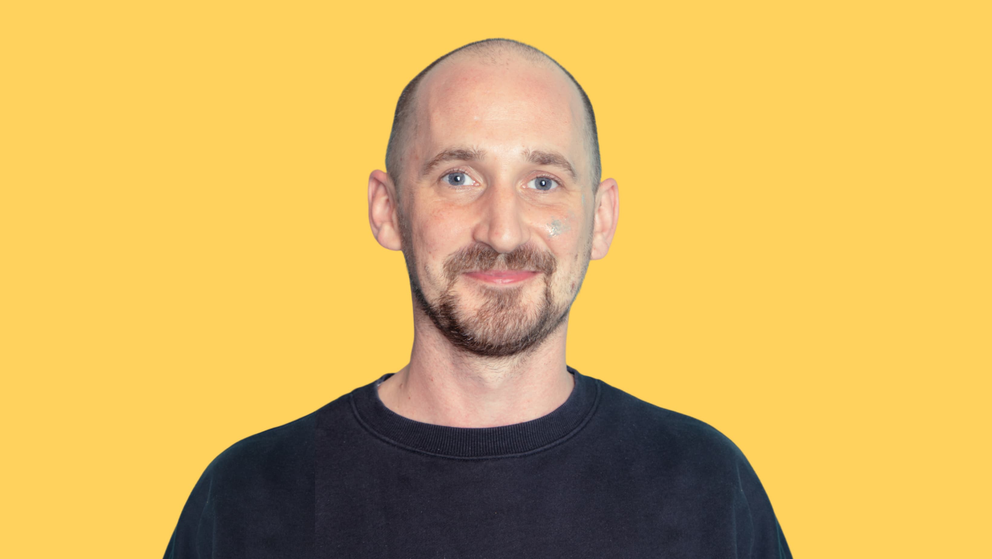 Portrait of a smiling man against a yellow background