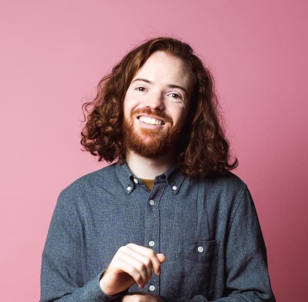 man standing and smiling - rose background