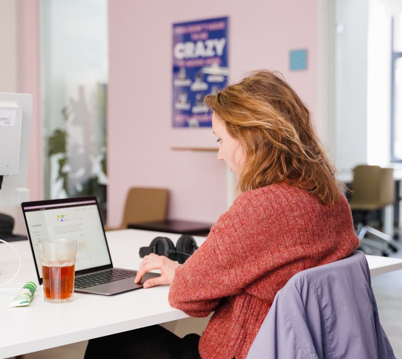 Woman working on a laptop in an office.